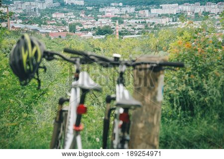 two bicycles stand on hill wth city view on background