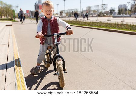 Photo of boy on run bicycle at road in park