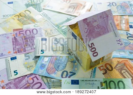 Euro house on euro banknotes money background.