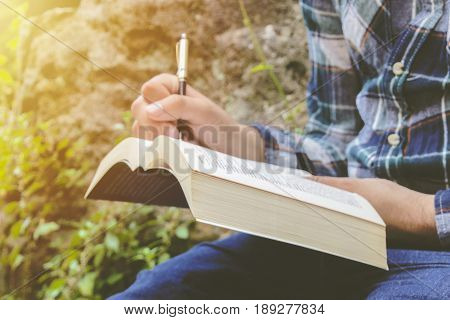 Male hand writing on paper. A man hand is write something. Writing notes in a notebook. Photo stock.