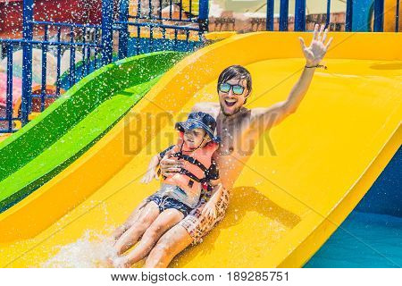 Father And Son On A Water Slide In The Water Park