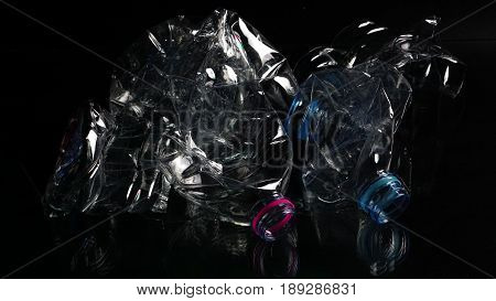 Plastic bottles on black background. The garbage can recycle.