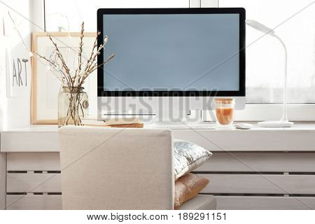 Creative workplace with monitor on windowsill in modern room