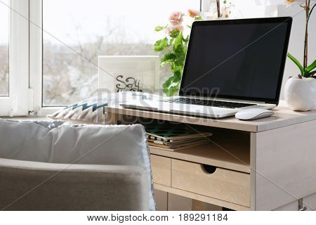 Creative workplace with laptop near windowsill in modern room