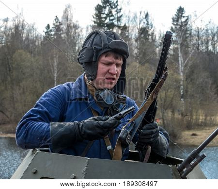 Gatchina, Russia - May 7, 2017: Historical reconstruction of the battles of World War II. The driver of the armored car. Dressed in overalls and a tank headset.