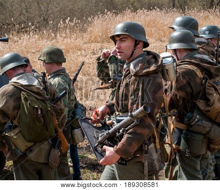 Gatchina, Russia - May 7, 2017: Historical reconstruction of the battles of World War II. The participants in the form of German soldiers preparing for battle.