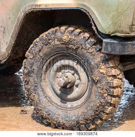 Dirty wheel of an off-road car after driving in the rain