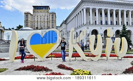 KYIV UKRAINE - CIRCA MAY 2017: Celebration 1535-th Day of Kyiv. Young pair stay near stylized banner I LOVE KYIV for image taking