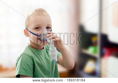 Boy making inhalation with nebulizer at home. child asthma inhaler inhalation nebulizer steam sick cough concept