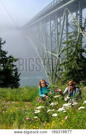 Happy women hiking by ocean in foggy morning. Deception Pass Bridge Park. Seattle. Anacortes. Washington. United States.