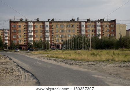 Modern five-storeyed house with flats. It was colored in red, orange and white colors