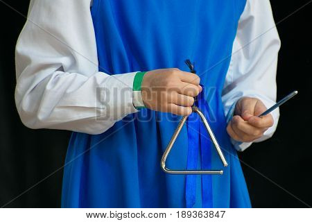 A Girl With Triangle Performing On Stage.