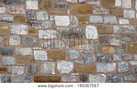 old stone wall historical built with various stones background