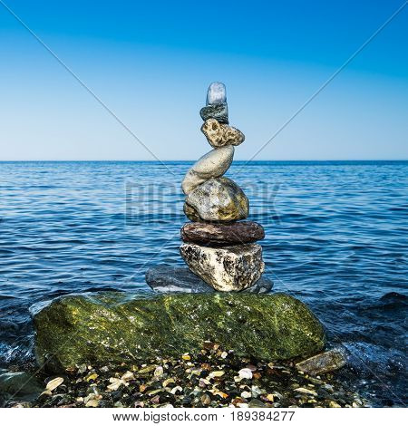 Colorful zen balancing rocks with blue sea background
