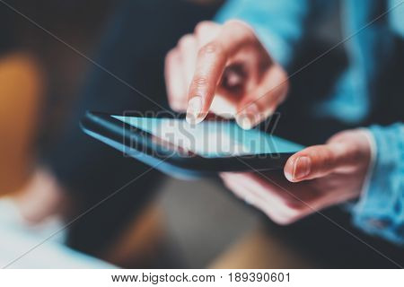 Closeup view of woman holding modern smartphone in hands.Girl typing on white touch mobile screen. Horizontal, blurred background, bokeh effects.Macro