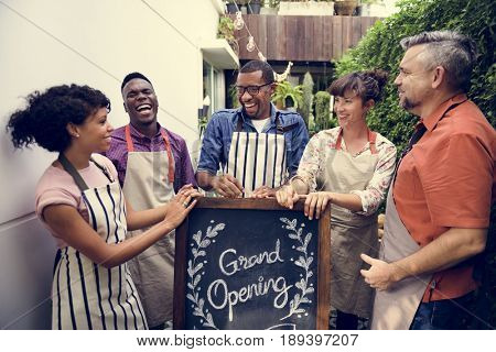Group of friends with grand opening board together
