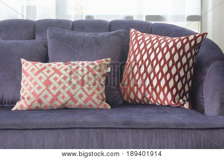 Red Pattern Pillows Lay On Vilolet Sofa In Living Room
