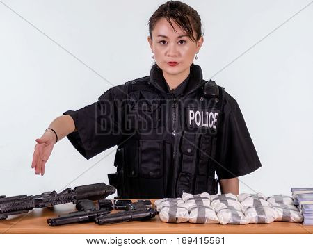 Female Asian Police Officer Showing Seized Goods