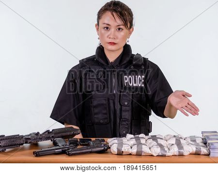 Female Asian Police Officer Showing Seized Goods