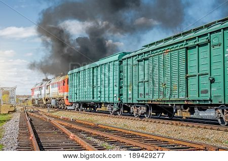 Freight train railroad departure from starion with black smoke