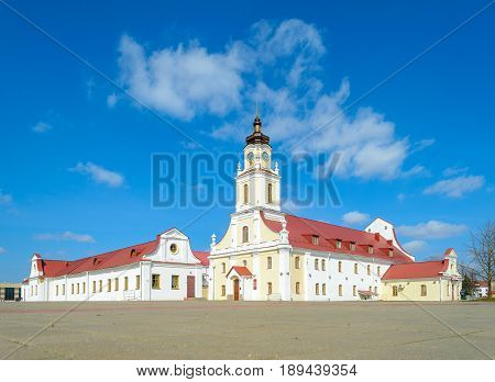 Belarus Orsha - April 11 2017: Old Town Hall in Orsha Belarus. The white building with a tower in the Baroque style with a red roof against the blue sky with clouds.