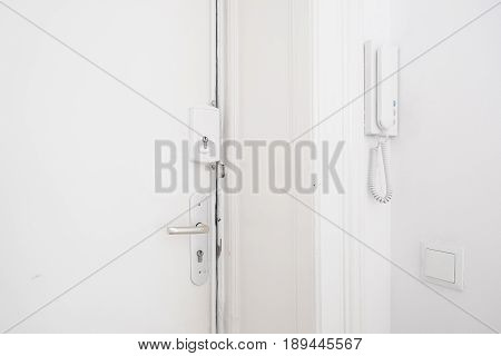 Door Handle , Bar Lock And Interphone System On White Apartment Door