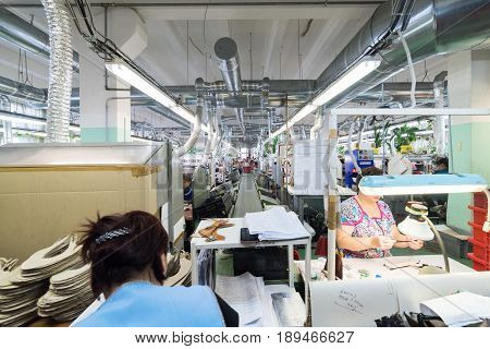 MOSCOW, RUSSIA - FEBRUARY 21, 2017: Moscow shoe factory JSC RALF RINGER . Female and male workers on a sewing machine.