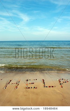 Word Hjælp på strandsand, lavet af sten