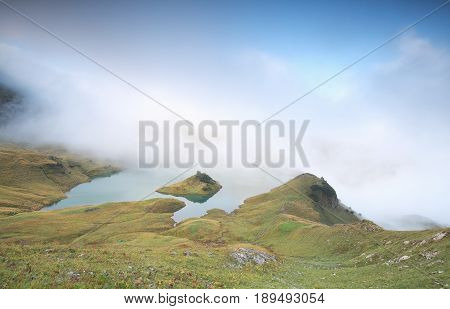 low fog over alpine lake in morning Schrecksee