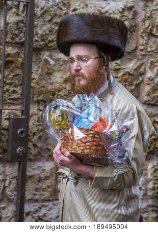 JERUSALEM - MARCH 13 : Ultra Orthodox man holding Mishloach Manot during Purim in Mea Shearim Jerusalem on March 13 2017 Mishloach Manot is traditional food gifts given during Purim
