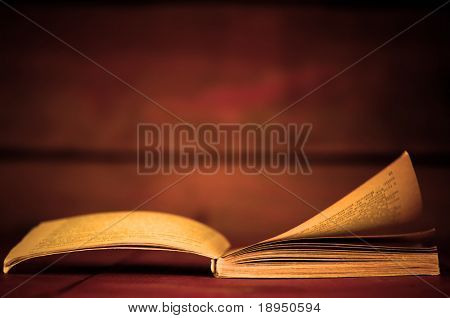Libro abierto en estilo retro sobre fondo de madera. Conceptos de la educación