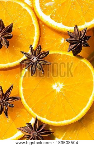 bright orange background from slices of juicy oranges with anise stars cinammon