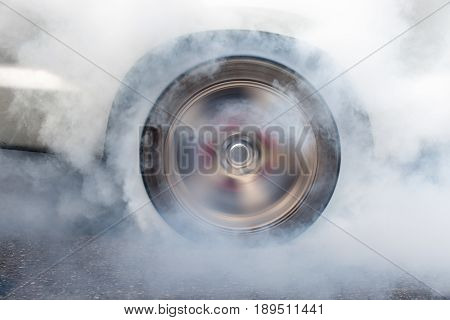Race car burns rubber off its tires in preparation for the race