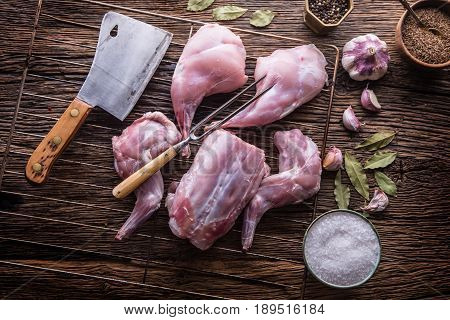 Rabbit. Raw rabbit slices with spices garlic kitchen utensilfork and butcher. Hunting cuisine.