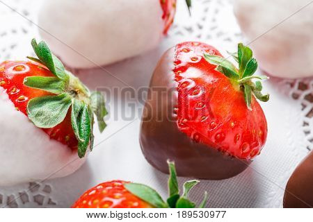 Fresh strawberries dipped in dark and white chocolate on light background close up. Delicious dessert and candy bar. Top view