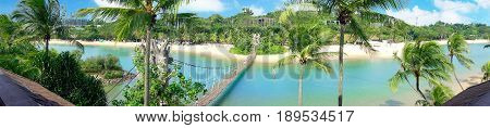 Sunny Palawan Beach and Southernmost point of continental Asia bridge of Sentosa Island in Singapore.