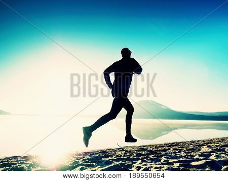 Healthy Lifestyle. Tall Young Man Runner Is Running On Sunrise Seaside. Man Jump In Sand