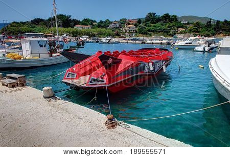 VASILIKOS, ZAKYNTHOS ISLAND, GREECE, JUNE 02, 2016: Red speed boat Dake Devil jet for tourists. Agressive design boat. Greece islands holidays trips to Blue caves. Sport car style Ferrari boat