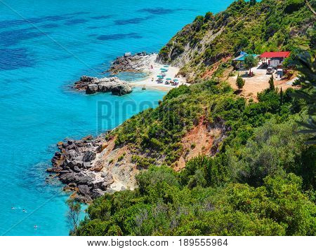 Beautiful view on amazing island bay with swimming and toasting people on sand snd stone beach, Ionian Sea blue water, close to Xigia beach on Zakynthos island. Greece holidays on Greece islands