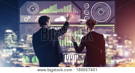 Two business people standing with back and working together with virtual screen