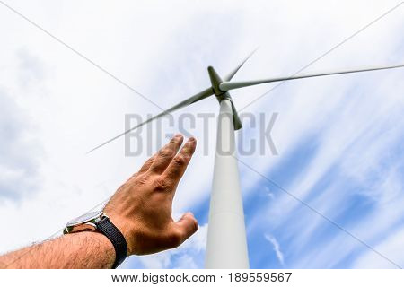 Human hand aiming to wind power turbines generate electricity .