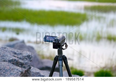 The camcorder takes a wild landscape. Video nature sea sunset. The creativity of the filmmakers during the journey on the planet.