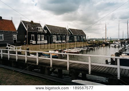 Marken Netherlands - August 08 2016. Picturesque traditional houses in the fishing harbour of Marken. It is known for its characteristic wooden houses and traditional costumes.