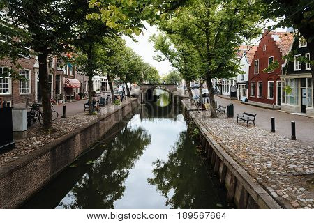 Monnickendam Netherlands - August 08 2016. Street view with old traditional houses and canal in the dutch village of Monnickendam. The town was founded by monks and it is a small fishing village today