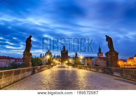 View of Charles Bridge in Prague with blue sky and clouds, Czech Republic during blue hour sunrise.