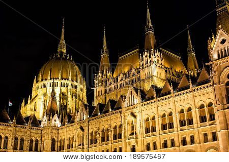 Budapest parliament building at night with dark sky.