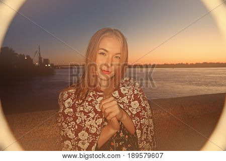Ring flash shot of long haired girl looking at camera in night time