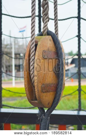 ancient wooden sailboat pulley on an old restored dutch VOC ship