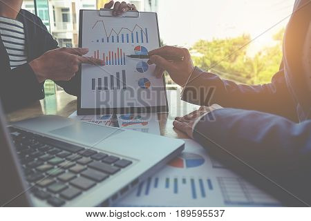 Business concept. Business people discussing the charts and graphs showing the results of their successful teamwork.