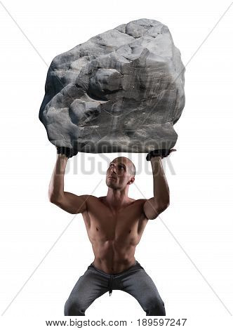Muscular man with determination lifts a big boulder